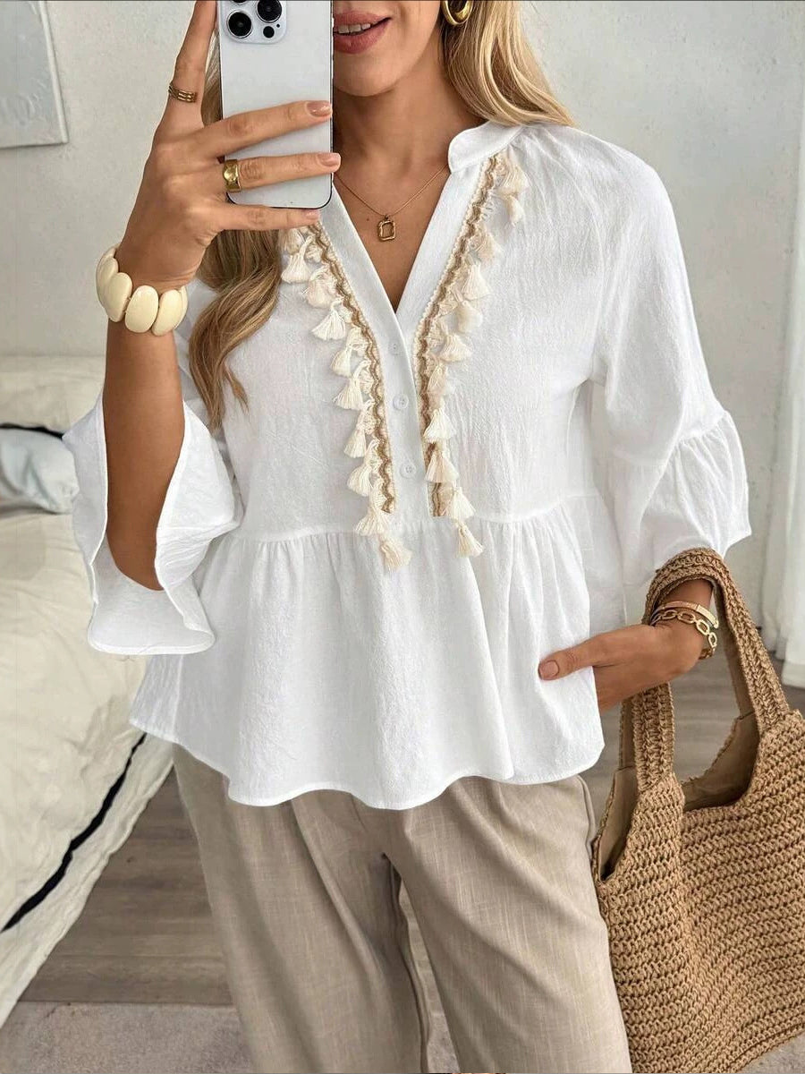 Top de mujer con cuello en V, botones y borlas.