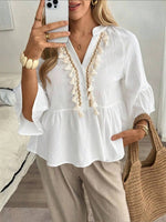 Top de mujer con cuello en V, botones y borlas.