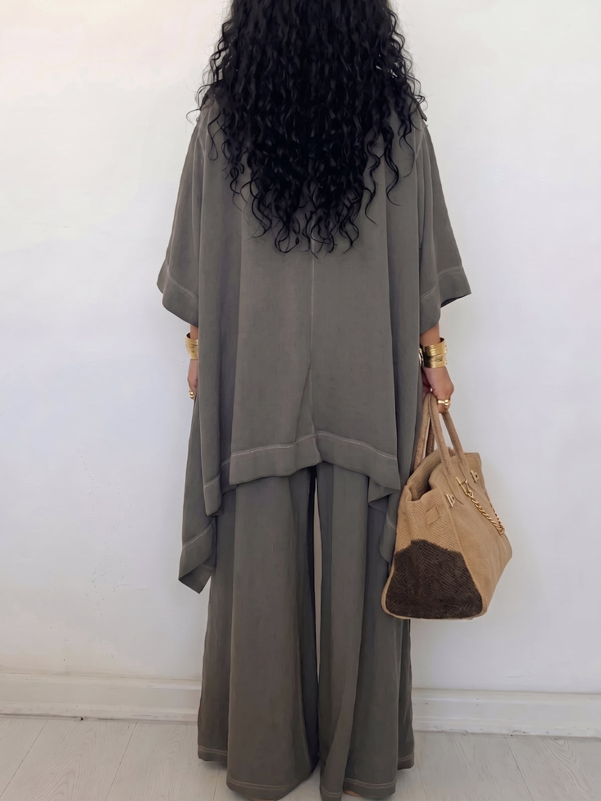 Conjunto de dos piezas para mujer: camisa holgada abotonada y pantalón de pierna ancha. Un atuendo informal y relajado con detalles de ojales metálicos.