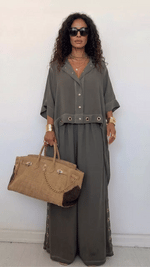 Conjunto de dos piezas para mujer: camisa holgada abotonada y pantalón de pierna ancha. Un atuendo informal y relajado con detalles de ojales metálicos.