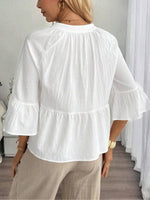 Top de mujer con cuello en V, botones y borlas.